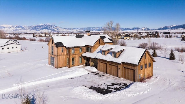 snowy aerial view featuring a mountain view