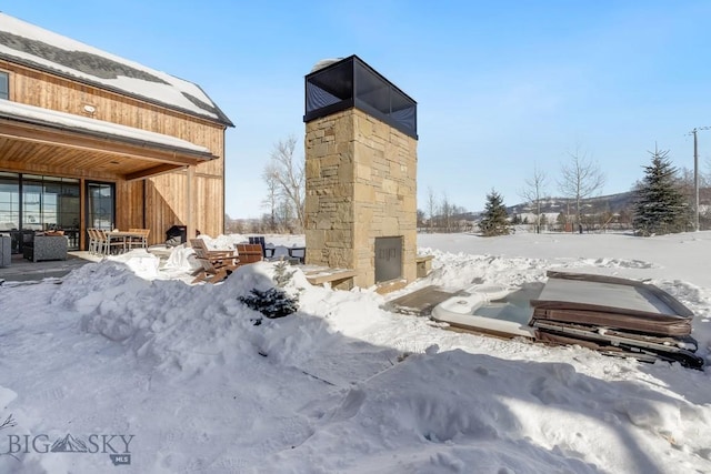 exterior space with an outdoor stone fireplace and a jacuzzi