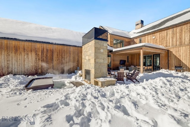 snow covered house with an outdoor fire pit