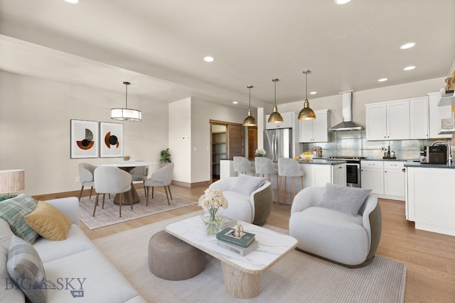 living room featuring sink and light hardwood / wood-style floors