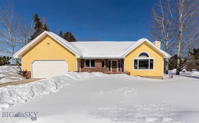 single story home featuring brick siding, a chimney, and an attached garage