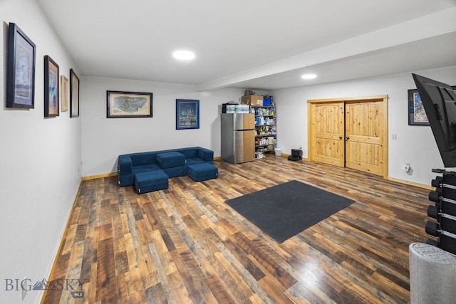 sitting room featuring baseboards, wood finished floors, and recessed lighting