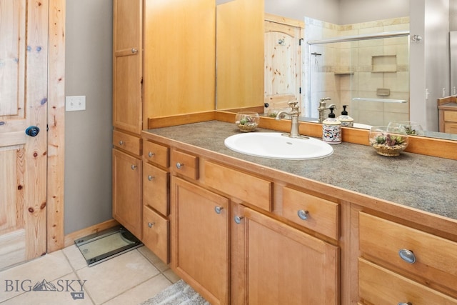 full bath with vanity, tile patterned flooring, and a stall shower