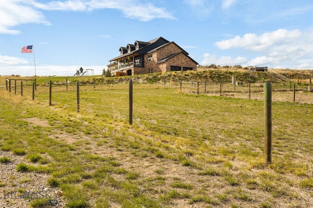 view of yard featuring fence and a rural view