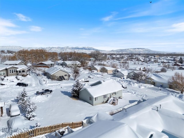 snowy aerial view featuring a residential view and a mountain view