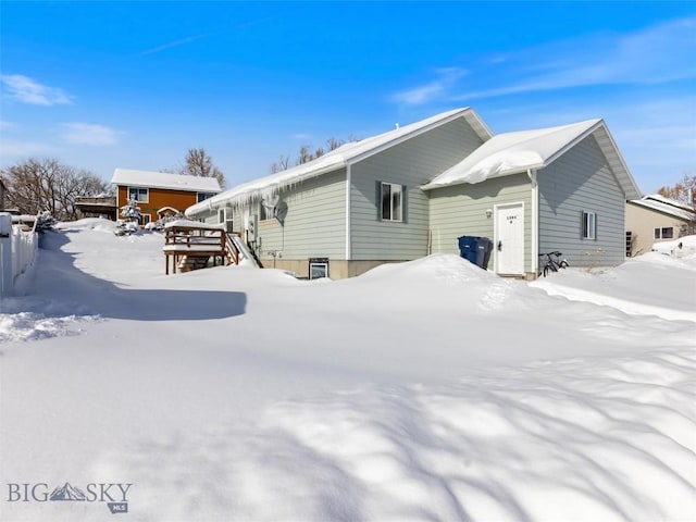 view of snow covered rear of property