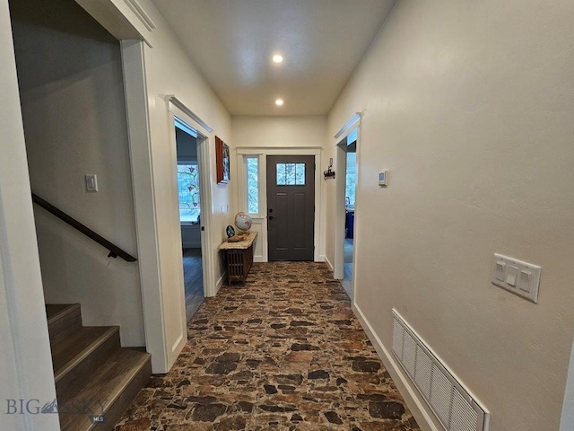 doorway featuring baseboards, visible vents, stone finish floor, stairs, and recessed lighting