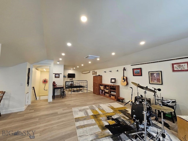 exercise area featuring light wood finished floors, lofted ceiling, recessed lighting, visible vents, and baseboards