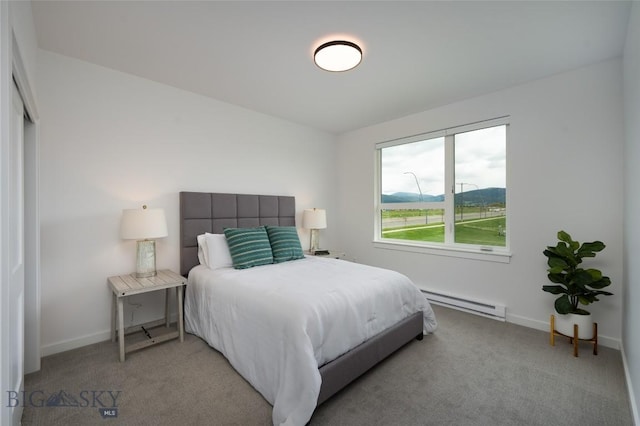 bedroom with light carpet, baseboards, and a baseboard heating unit