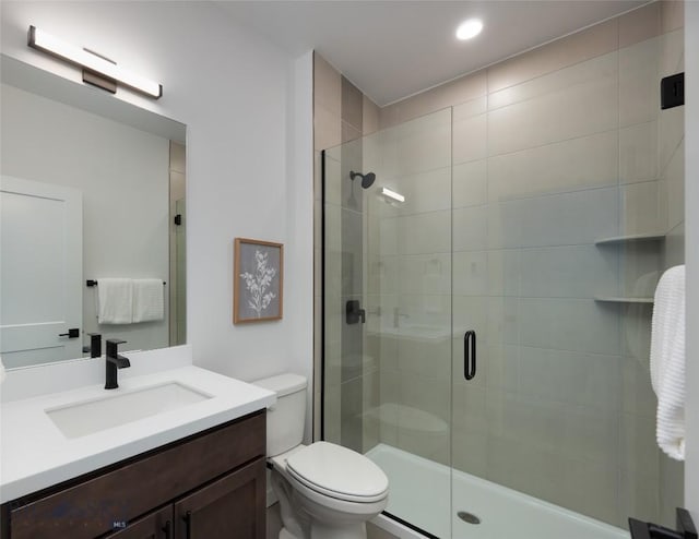 full bath with vanity, toilet, and a shower stall