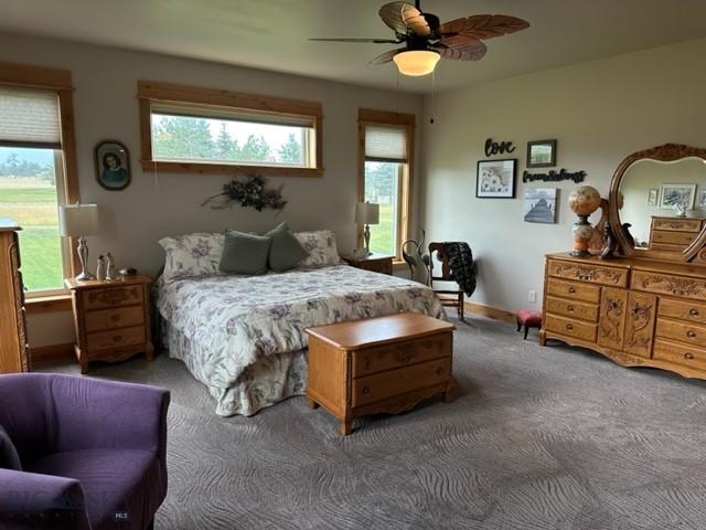 carpeted bedroom with a ceiling fan and baseboards