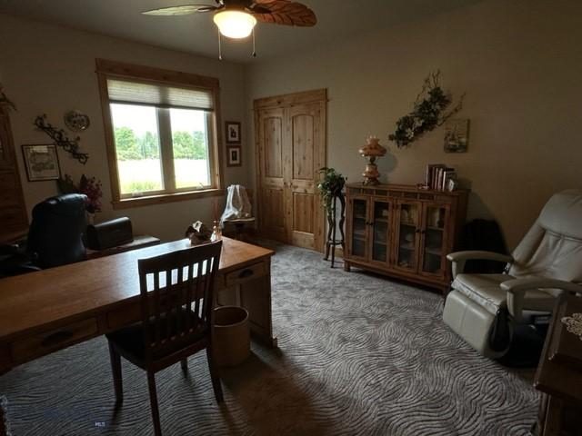 carpeted office space featuring a ceiling fan