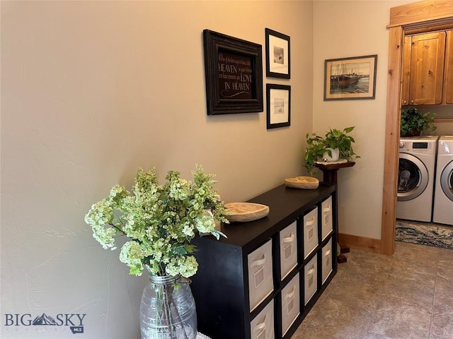 washroom with cabinet space, washing machine and dryer, and baseboards