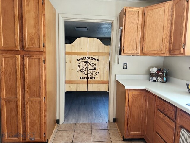 kitchen featuring light tile patterned flooring, brown cabinetry, and light countertops