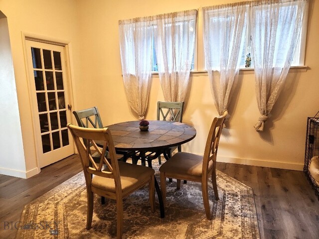 dining room featuring baseboards, a healthy amount of sunlight, and wood finished floors