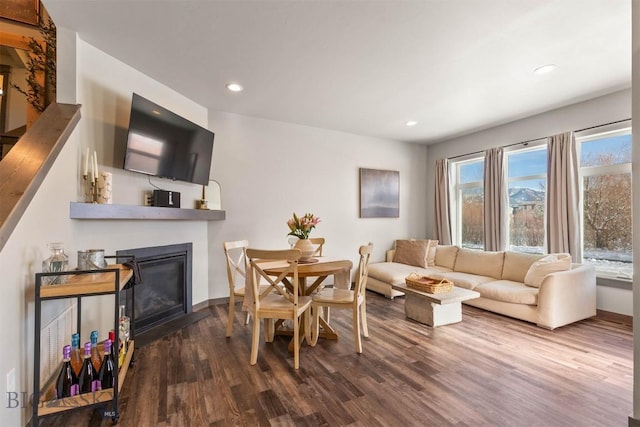 dining space featuring recessed lighting, baseboards, wood finished floors, and a glass covered fireplace