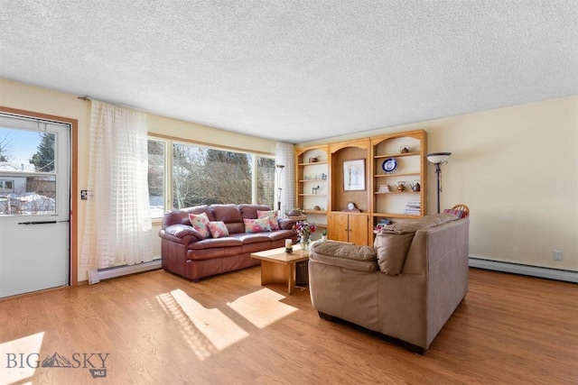 living area featuring a baseboard radiator, a textured ceiling, and light wood finished floors