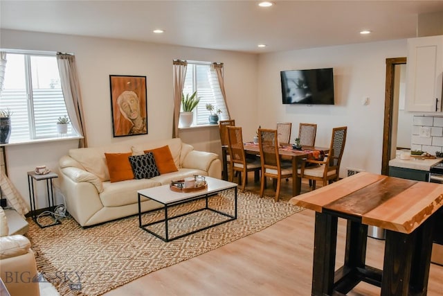 living area with light wood-type flooring and recessed lighting