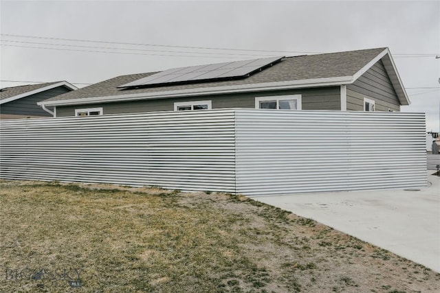 view of home's exterior featuring a lawn and roof mounted solar panels