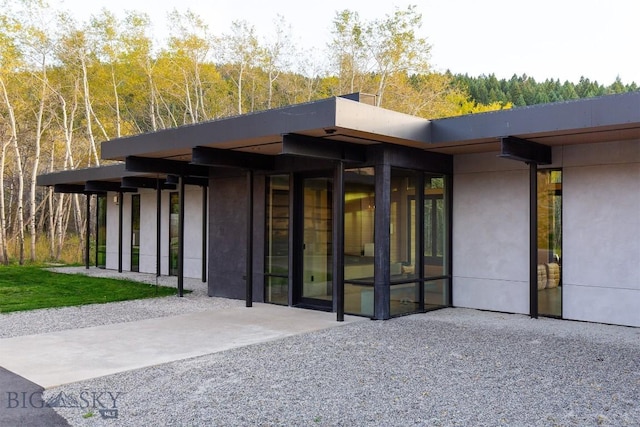 view of exterior entry featuring a view of trees