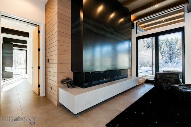 living area with tile patterned flooring and a multi sided fireplace