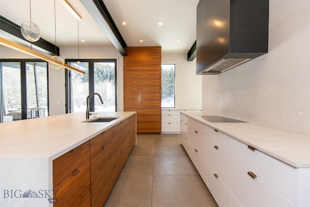 kitchen featuring a sink, white cabinets, light countertops, island exhaust hood, and a center island with sink