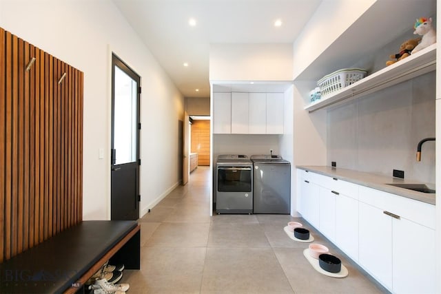 kitchen featuring open shelves, light countertops, white cabinets, a sink, and independent washer and dryer