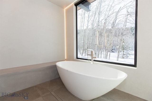 bathroom featuring a freestanding tub and tile patterned floors