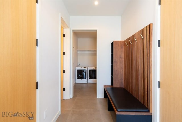 corridor with light tile patterned flooring and independent washer and dryer