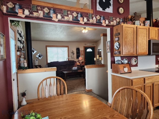 dining room with a ceiling fan and a wood stove