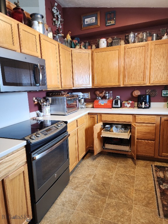 kitchen featuring stainless steel appliances, light countertops, and a toaster