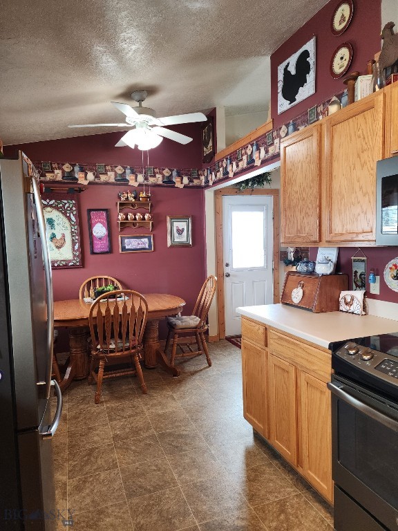 kitchen featuring appliances with stainless steel finishes, light countertops, a textured ceiling, and a ceiling fan