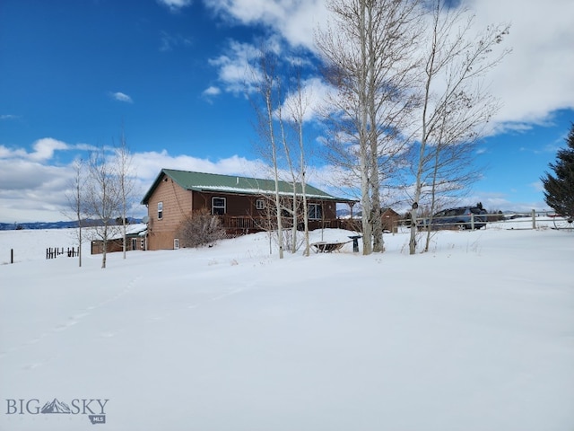 view of snow covered back of property