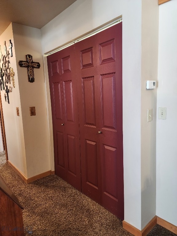 hall featuring carpet floors and baseboards