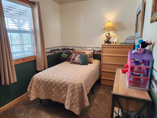 bedroom with dark carpet and baseboards