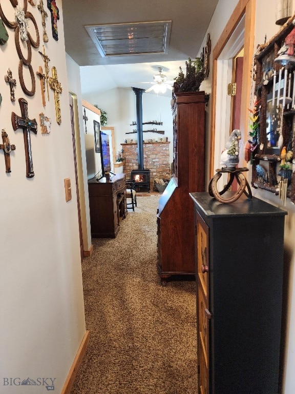 corridor with lofted ceiling, carpet, and baseboards