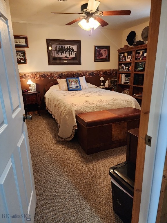 bedroom featuring wainscoting, carpet, and a ceiling fan