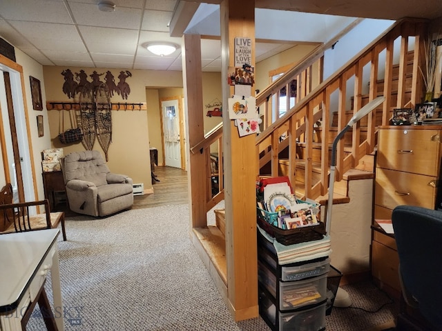 interior space featuring a paneled ceiling, carpet, and a baseboard radiator