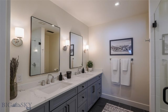 bathroom featuring double vanity, baseboards, a sink, and tile patterned floors