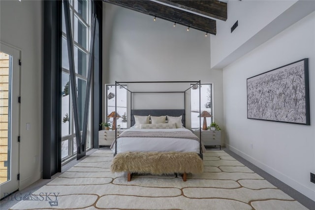 bedroom featuring a high ceiling, baseboards, and beamed ceiling