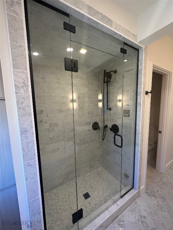 full bath with toilet and a stall shower