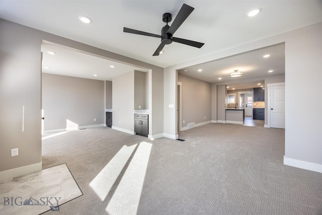 unfurnished living room with baseboards and light colored carpet