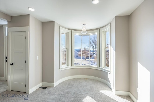 interior space featuring baseboards, recessed lighting, visible vents, and light colored carpet