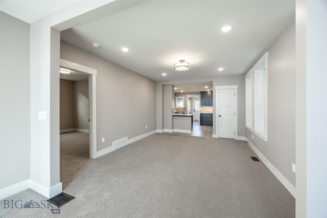 unfurnished living room featuring carpet, visible vents, and recessed lighting