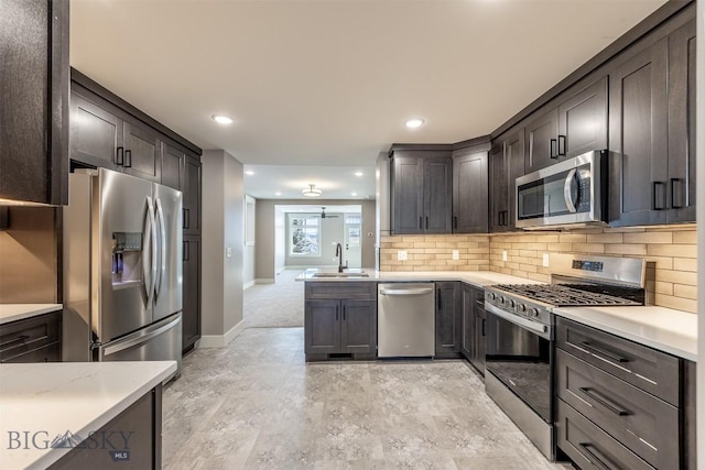 kitchen featuring a sink, dark brown cabinetry, stainless steel appliances, and light countertops