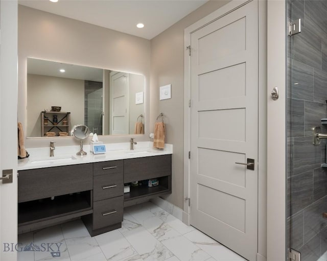 full bath featuring marble finish floor, double vanity, a sink, and a shower stall