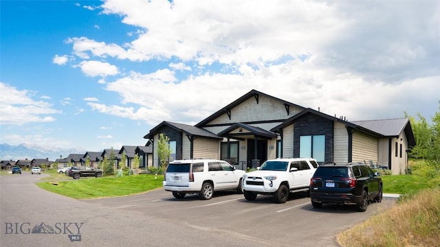 view of front facade with uncovered parking, a residential view, and metal roof