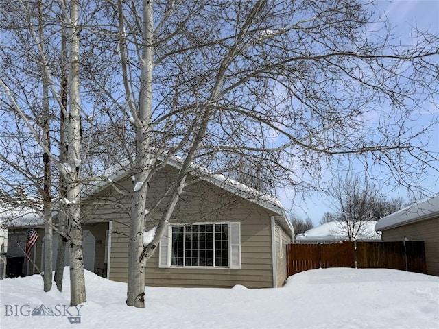 view of snow covered exterior featuring fence