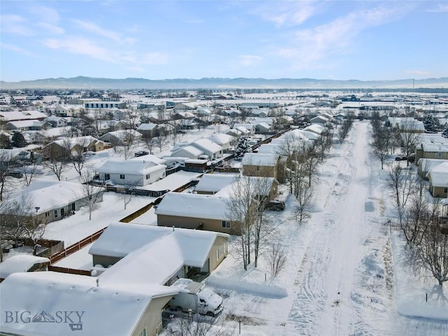 snowy aerial view with a residential view and a mountain view