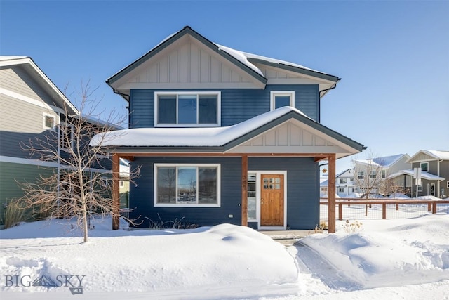 view of front facade featuring covered porch, board and batten siding, and fence